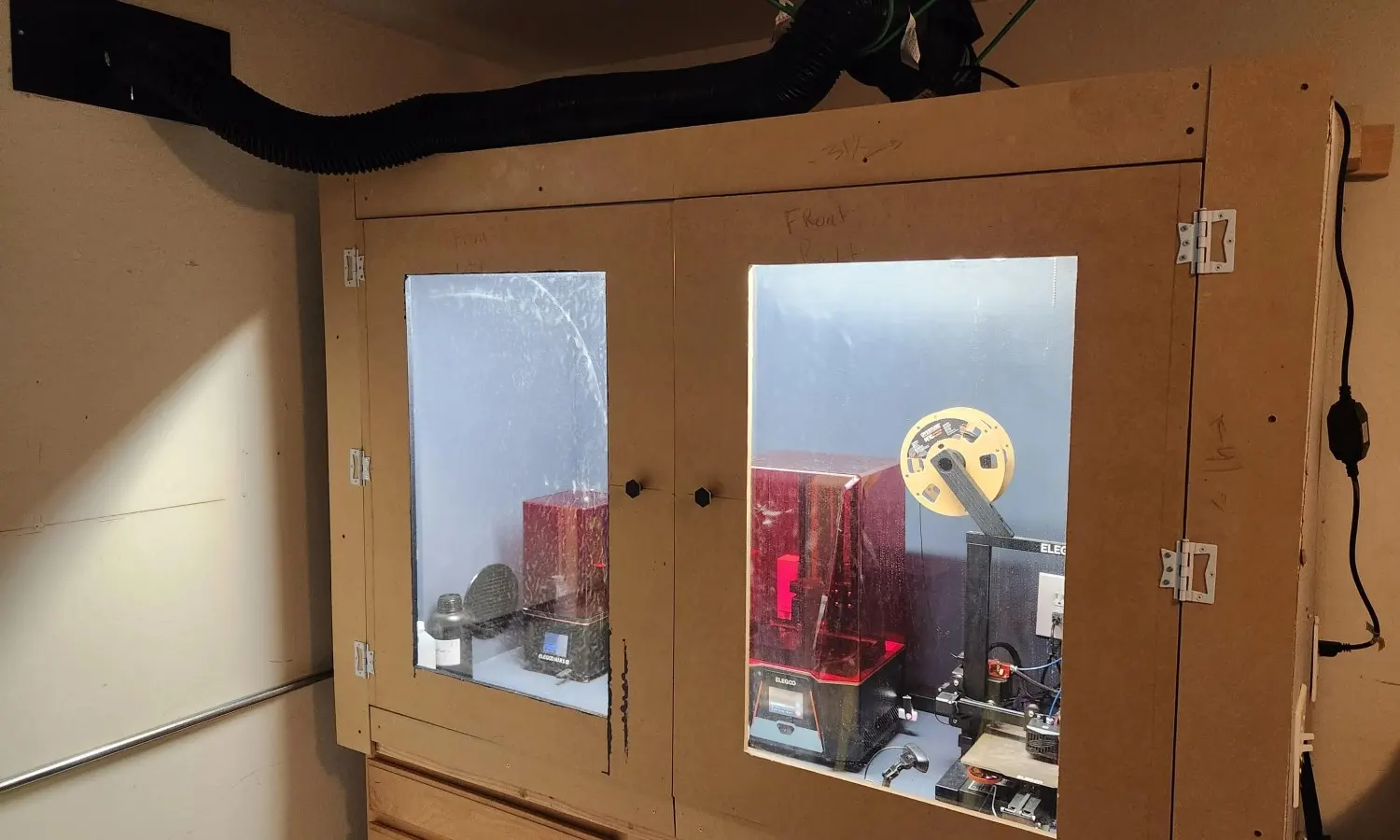 Resin printers in an enclosure that is vented outdoors via a fan and duct