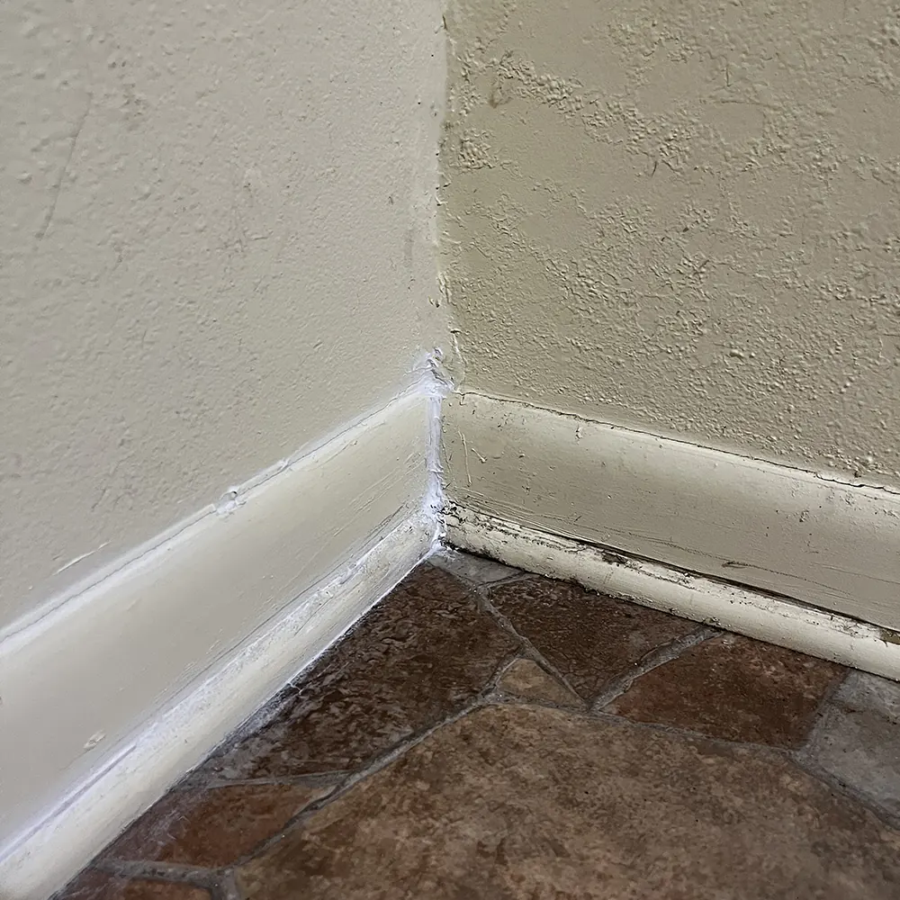 Caulking floor trim in our resin room to prevent bugs and air leaks